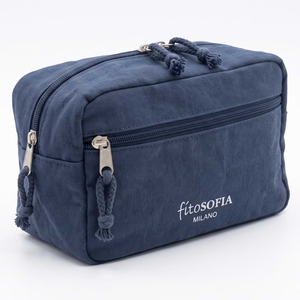 Beauty case da viaggio in tela blu scuro, con logo Fitosofia, due scomparti con cerniera e tiralampo a corda intrecciata, su sfondo chiaro.